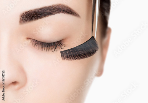 Eyelash removal procedure close up. Beautiful Woman with long lashes in a beauty salon.
