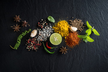 Leinwandbilder Kräuter Flatlay Gewürze auf dunklem Stein  © kireewongfoto
