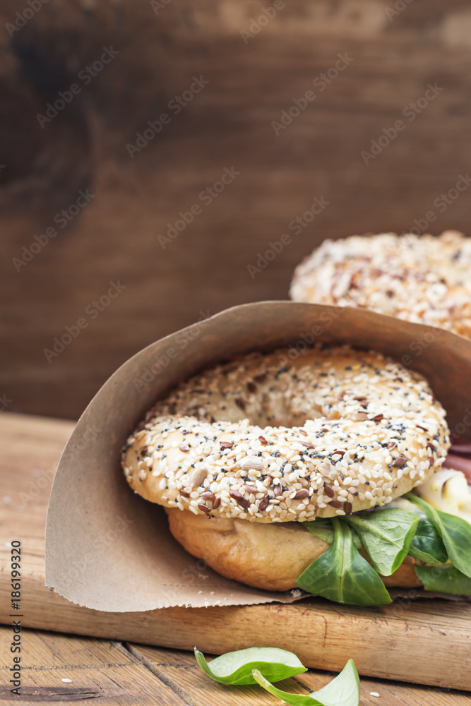 Bagels with salami and onion on a wooden board with free text space. Selective focus. Bagels with salami and onion on a wooden board with free text space. Selective focus.