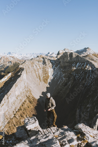 Traveler on top of rocky mountain edge photo