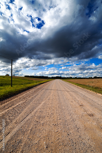 Gravel road in cloudy day.