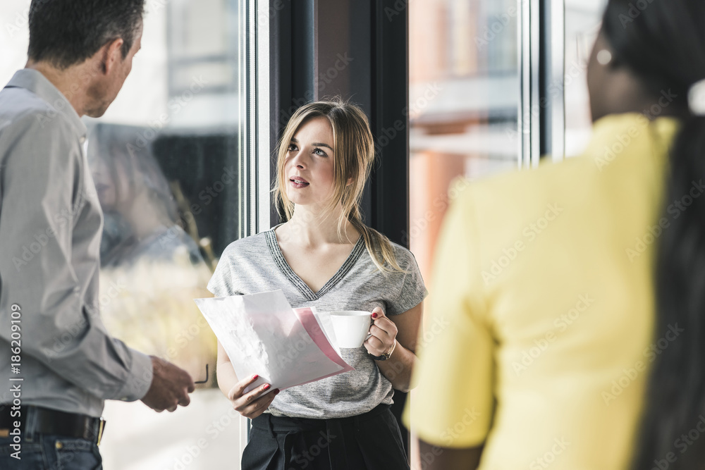 Business people talking at the window in office Business people talking at the window in office