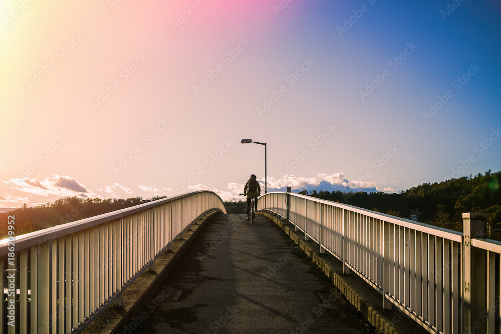Woman riding a bicycle climbs the bridge