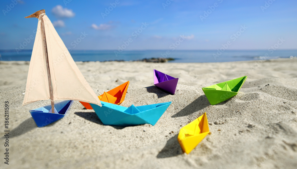 Foto Stock Papierboote mit Segel am Strand | Adobe Stock
