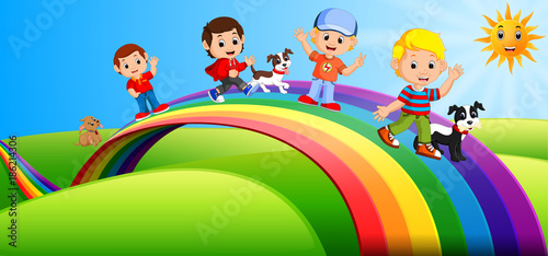 Happy kids and dogs standing over the rainbow