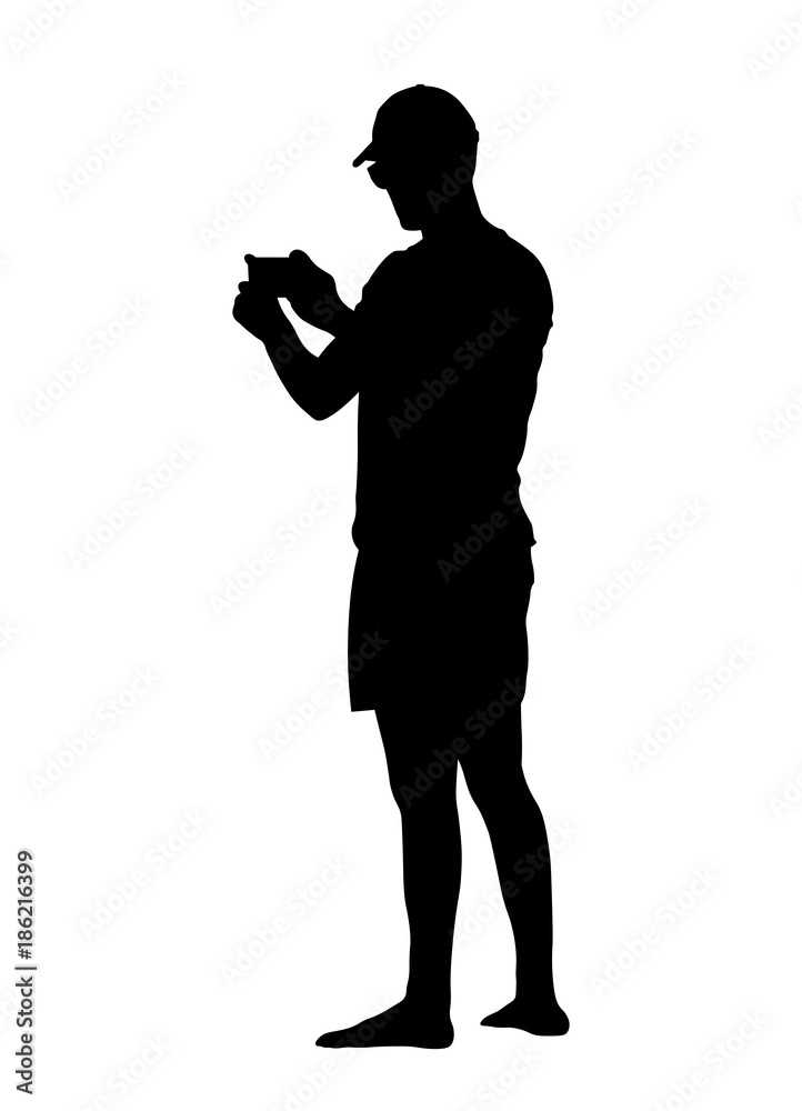 A black silhouette of a man in a cap who is photographing something on the phone. Take photos on memories on vacation