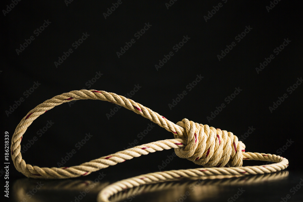 Brown rope noose dark and light on black table with black background,  concept of hanging suicide Stock Photo
