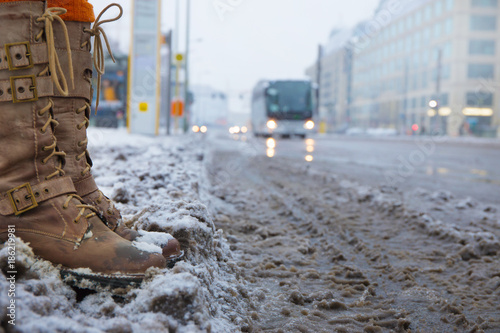 Принти на полотні in a city, a woman is standing in the slush at a bus stop