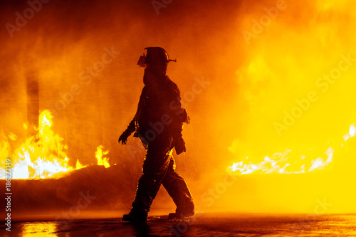 Fire chief walking in front of fire during firefighting exercise