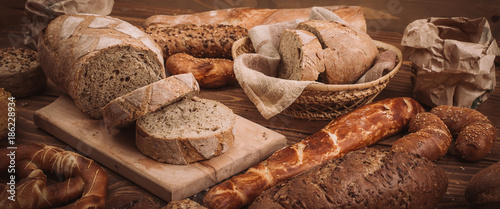 Various baked breads and rolls on rustic wooden table