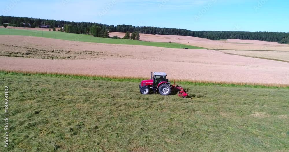 Plow tractor, Cinema 4k aerial sideway view following a plowing machine, harvesting on a grass field, on a sunny autumn day, in Uusimaa, Finland Plow tractor, Cinema 4k aerial sideway view following a plowing machine, harvesting on a grass field, on a sunny autumn day, in Uusimaa, Finland