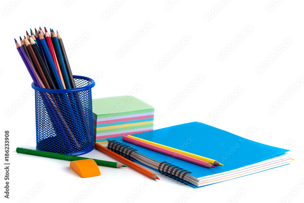 Fototapeta premium colored pencils in the basket, Eraser and notebook on white background