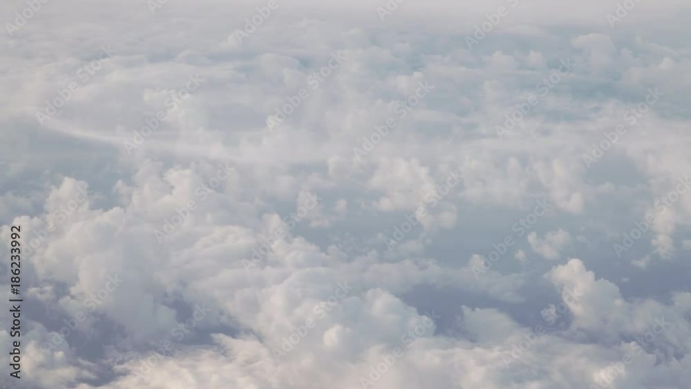 flying above the clouds in daytime view form airplane window flying above the clouds in daytime view form airplane window