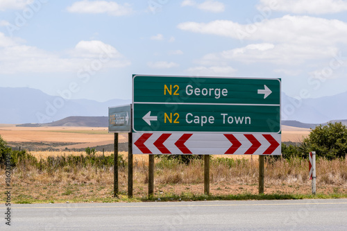 Road sign at the route N2 road in South Africa near Still Bay pointing to Cape Town and George. The N2 is a national route that runs from Cape Town to Ermelo and is the main highway along the ocean.