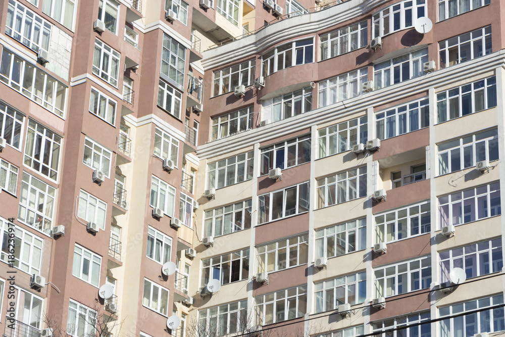 The facade of a typical block multi-storey residential building. Front view close up