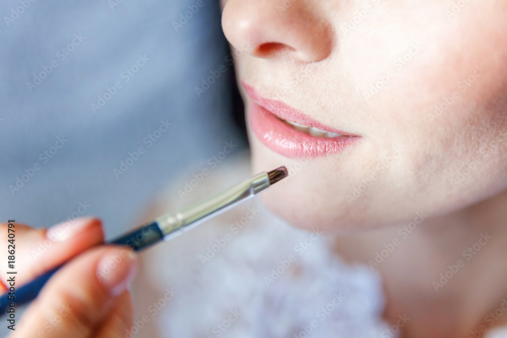 Closeup portrait of a woman having applied makeup by makeup artist