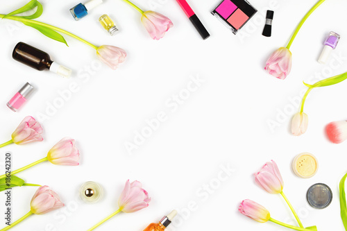 Flatlay with pink tulips, various makeup products, cosmetics and other beauty accessories. Concept of natural cosmetics and skincare, white background