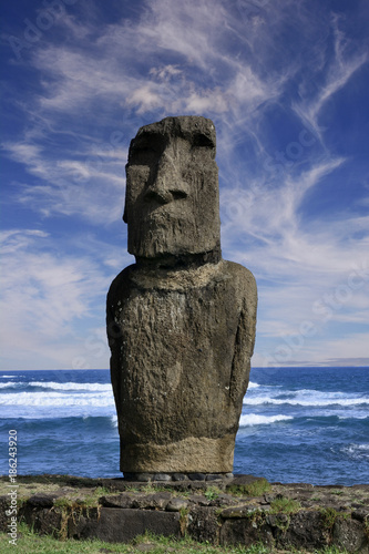 Eine stark verwitterte Moai Statue an der Küste auf der Osterinsel.
