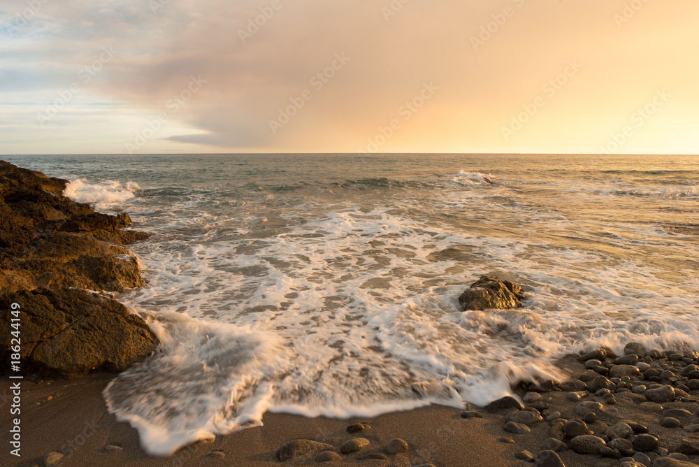 The calm sea in a very cloudy sunset