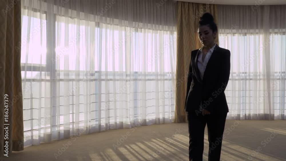 Charming businesswoman walks in her hotel room Charming businesswoman walks in her hotel room