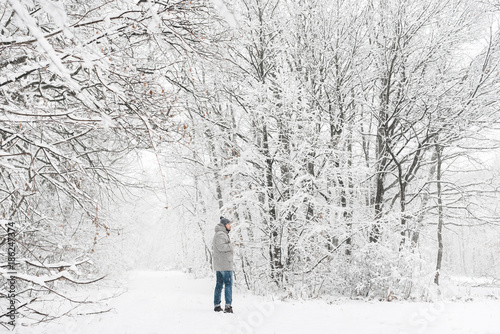 a man in a snowy forest view from afar © Andrii