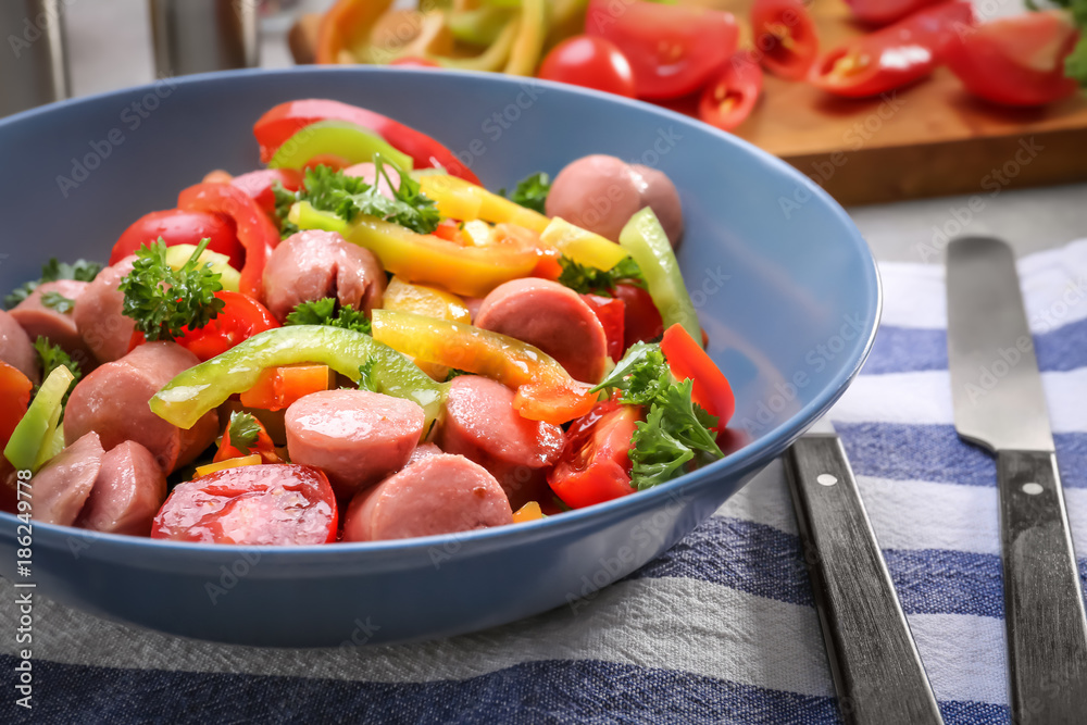 Vegetable salad with sausage in bowl on kitchen table Vegetable salad with sausage in bowl on kitchen table