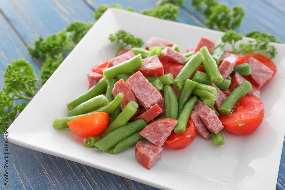 Plate with vegetable salad and sausage on table, closeup Plate with vegetable salad and sausage on table, closeup