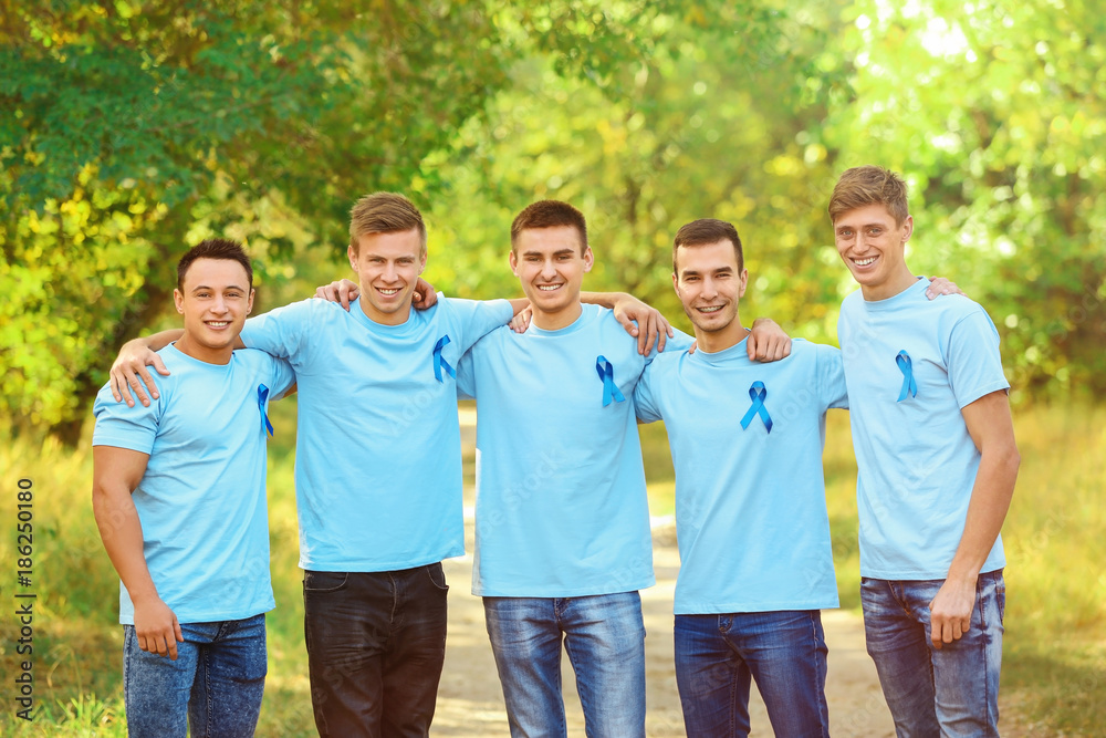 Φωτογραφία Young men in t-shirts with blue ribbons outdoors