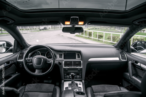 Modern luxury prestige car interior, dashboard, steering wheel. Black leather interior. © gorynvd