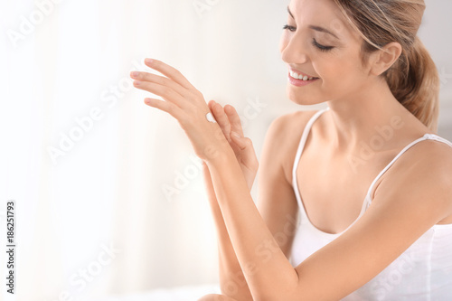Young woman applying hand c...