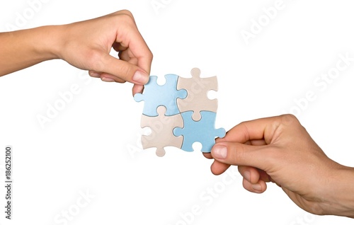 Closeup on Hands Combining Puzzle Pieces Together