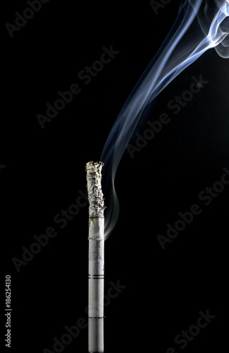 White lit cigarette on a black background, with lots of smoke coming from the side, bottom and top, and ash on the smoke