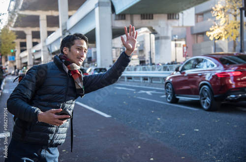 Man With Cellphone Hailing Taxi photo