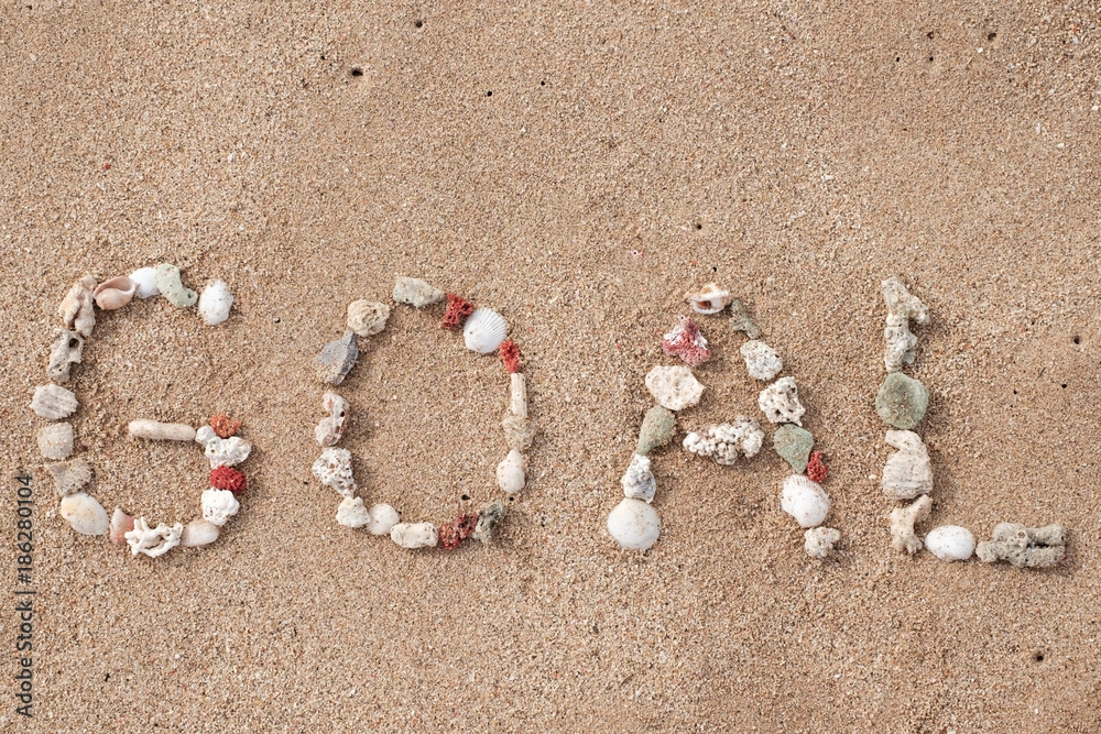Goal word made from shells on sandy beach. Concept of achievement in business Goal word made from shells on sandy beach. Concept of achievement in business