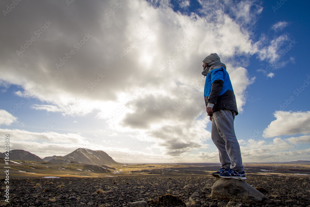 Pearson looking out into the landscape in Iceland, with a view from the top of a mountain