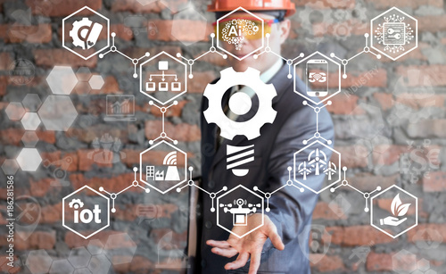 Businessman in  hard hat using virtual interface offers lightbulb cogwheel icon. Creative Idea Industrie 4.0 concept. Industrial IT. photo