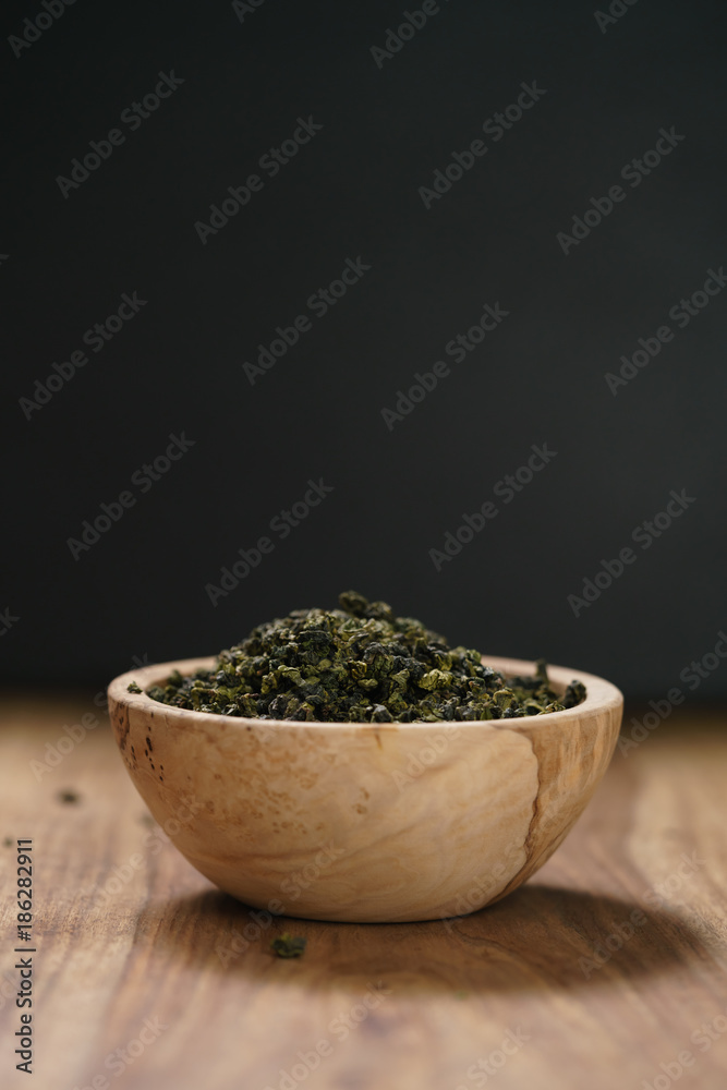 dry organic green oolong tea in wood bowl dry organic green oolong tea in wood bowl