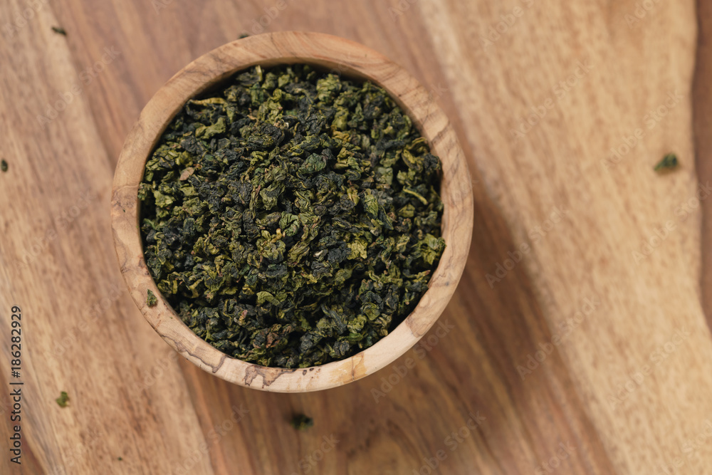 dry organic green oolong tea in wood bowl dry organic green oolong tea in wood bowl