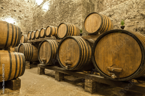 Wine barrels stacked in the old cellar of the winery