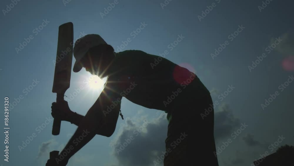 Silhouettes of young men ready to playing cricket in a park in Chennai, India