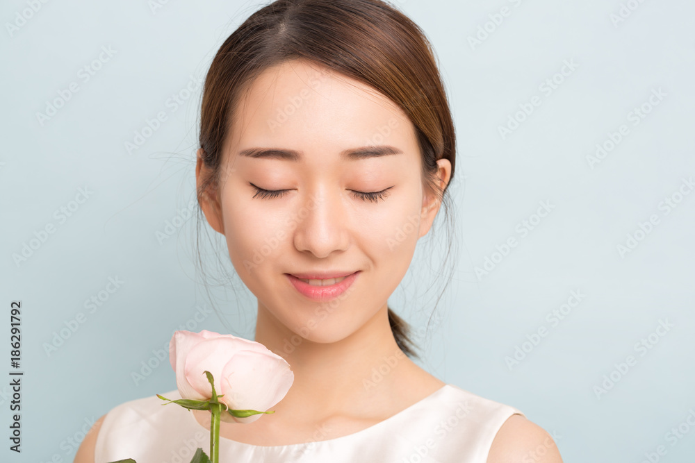 Portrait of a beautiful woman with pink rose.