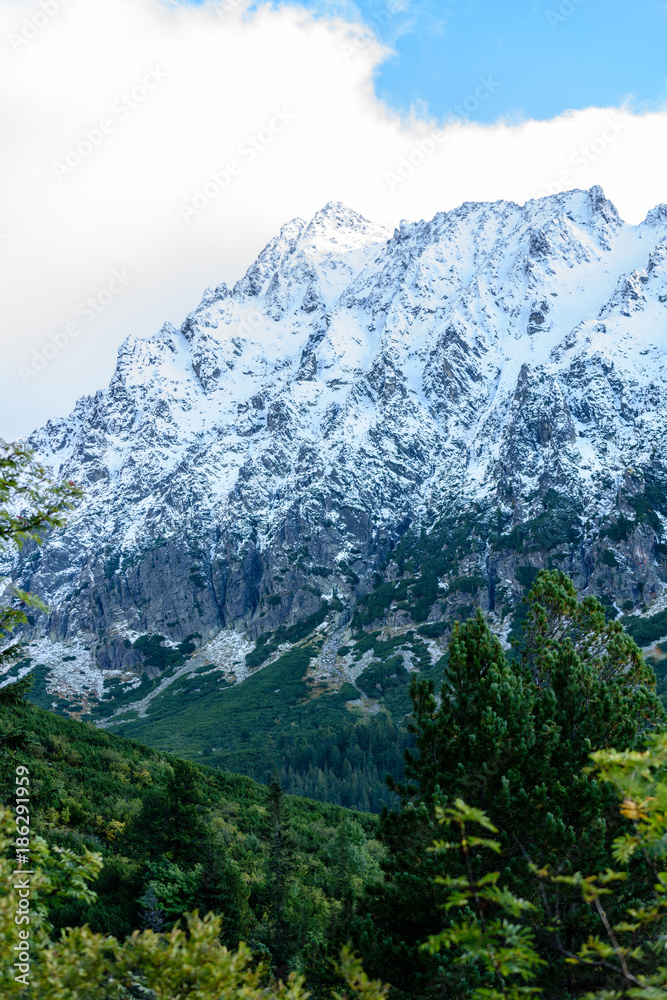 slovakian carpathian mountains in autumn. green hills with tops covered in first snow and white clouds above slovakian carpathian mountains in autumn. green hills with tops covered in first snow and white clouds above