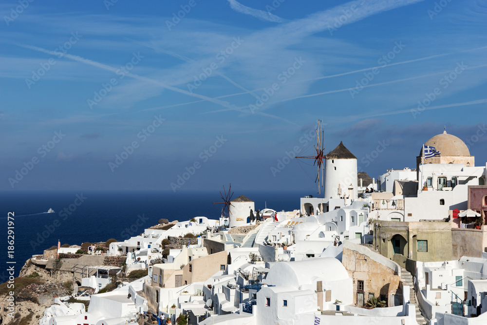 Old Town of Oia on the island Santorini, white houses, windmills and churchs with blue domes