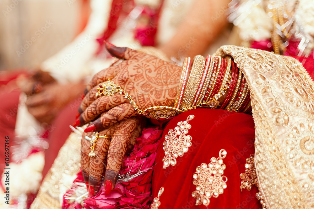 Hands of an Indian Bride, tattooed with natural and local dye, Mehndi or Henna. during a Hindu wedding ceremony.