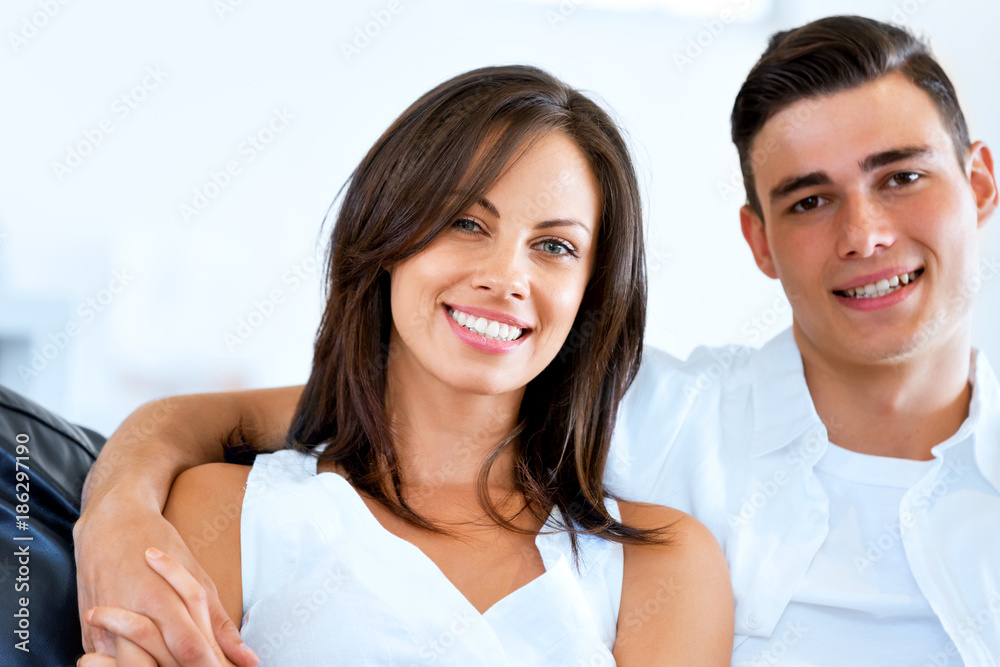 Young couple looking at camera while sitting at home Young couple looking at camera while sitting at home