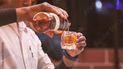 A bartender making whiskey peg in an Indian wedding.