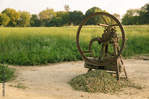 Hand operated old chaff, straw or grass cutter in Indian crop field.