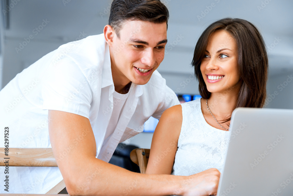 Happy modern couple working on laptop at home Happy modern couple working on laptop at home