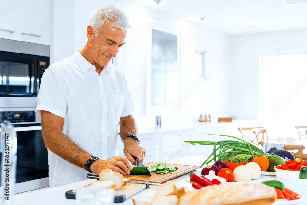 Portrait of a smart senior man standing in kitchen Portrait of a smart senior man standing in kitchen