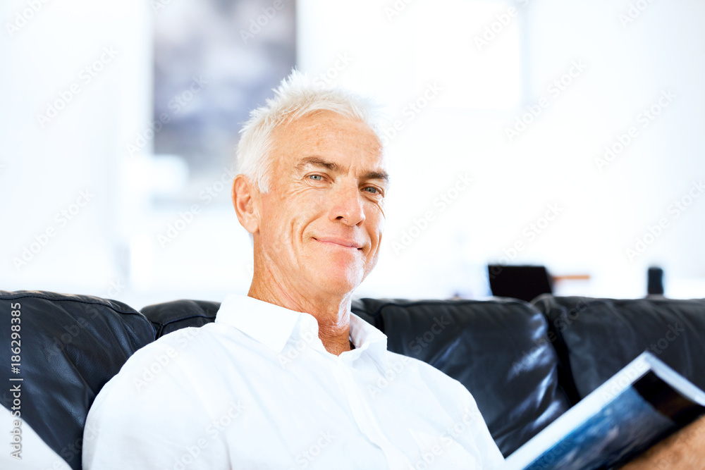Handsome sennior man reading a book relaxing on a sofa Handsome sennior man reading a book relaxing on a sofa